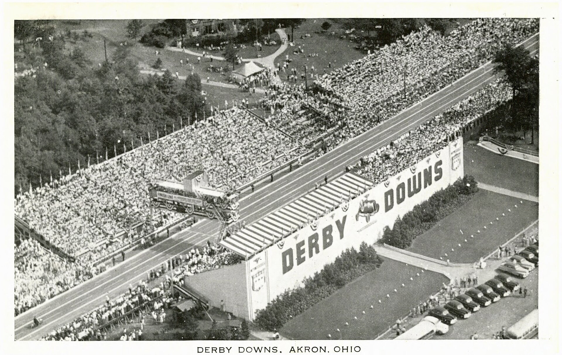Historic aerial view of Derby Downs beside Akron's municipal airport with the track, stands, and crowds visible